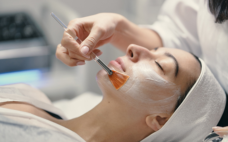 Esthetician applying a professional facial mask.