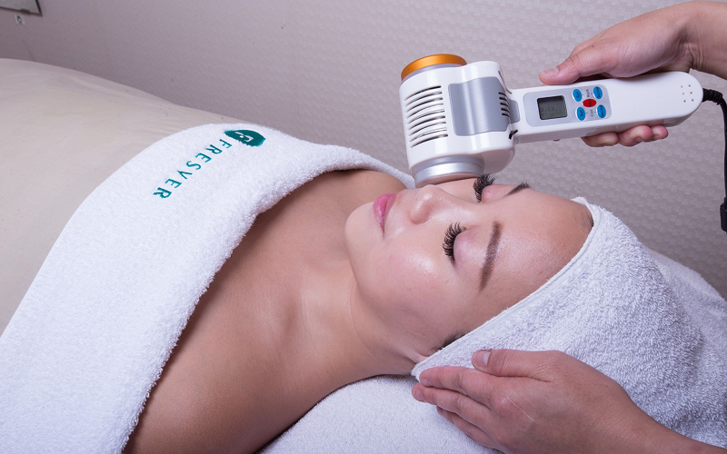 Specialist performing a cold therapy facial for skin recovery.